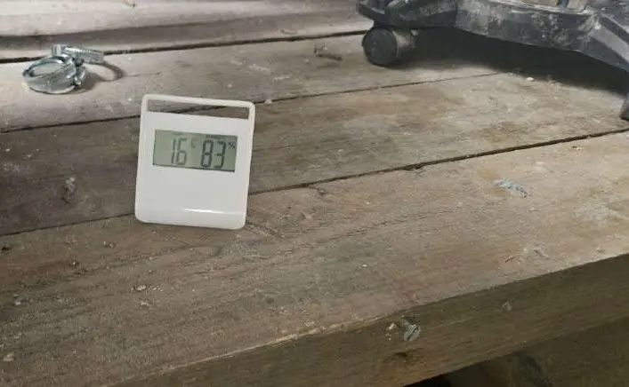 Hygromètre posé dans une cave, qui affiche 83 % d'humidité relative à 16 °C